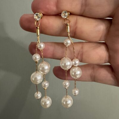 ✨ Pearl Dangle Bridal Earrings – Gulf Exclusive by Asloobi ✨ Elevate your wedding look with these gorgeous long pearl dangle earrings, designed for brides and bridesmaids who want timeless elegance. Measuring about 3 inches long, these earrings add a luxurious touch to your bridal style. 💍 Pair them with the matching necklace to complete your full wedding jewelry set. 🌟 Currently available in gold color to perfectly complement your dress. ✅ Premium quality guaranteed by Asloobi Store. Shipping Options: Standard Shipping: 4 – 6 business days Priority Mail Shipping: 2 – 3 business days 📦 International Orders: Please note, customers are responsible for all duties & taxes. Pearl Dangle Bridal Earrings